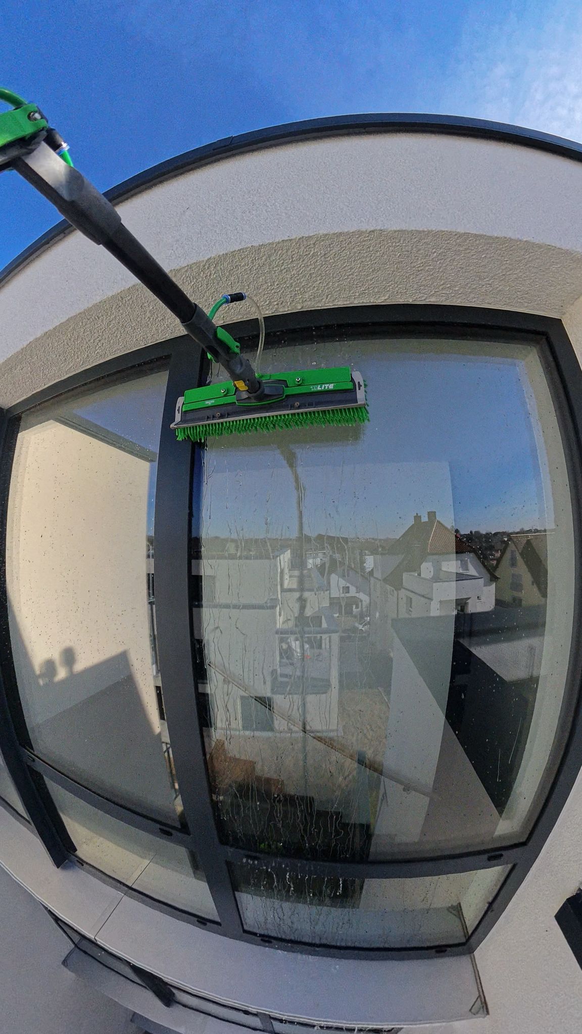 Reinigung eines hoch liegenden Fensters mit der Teleskop-Waschbürste